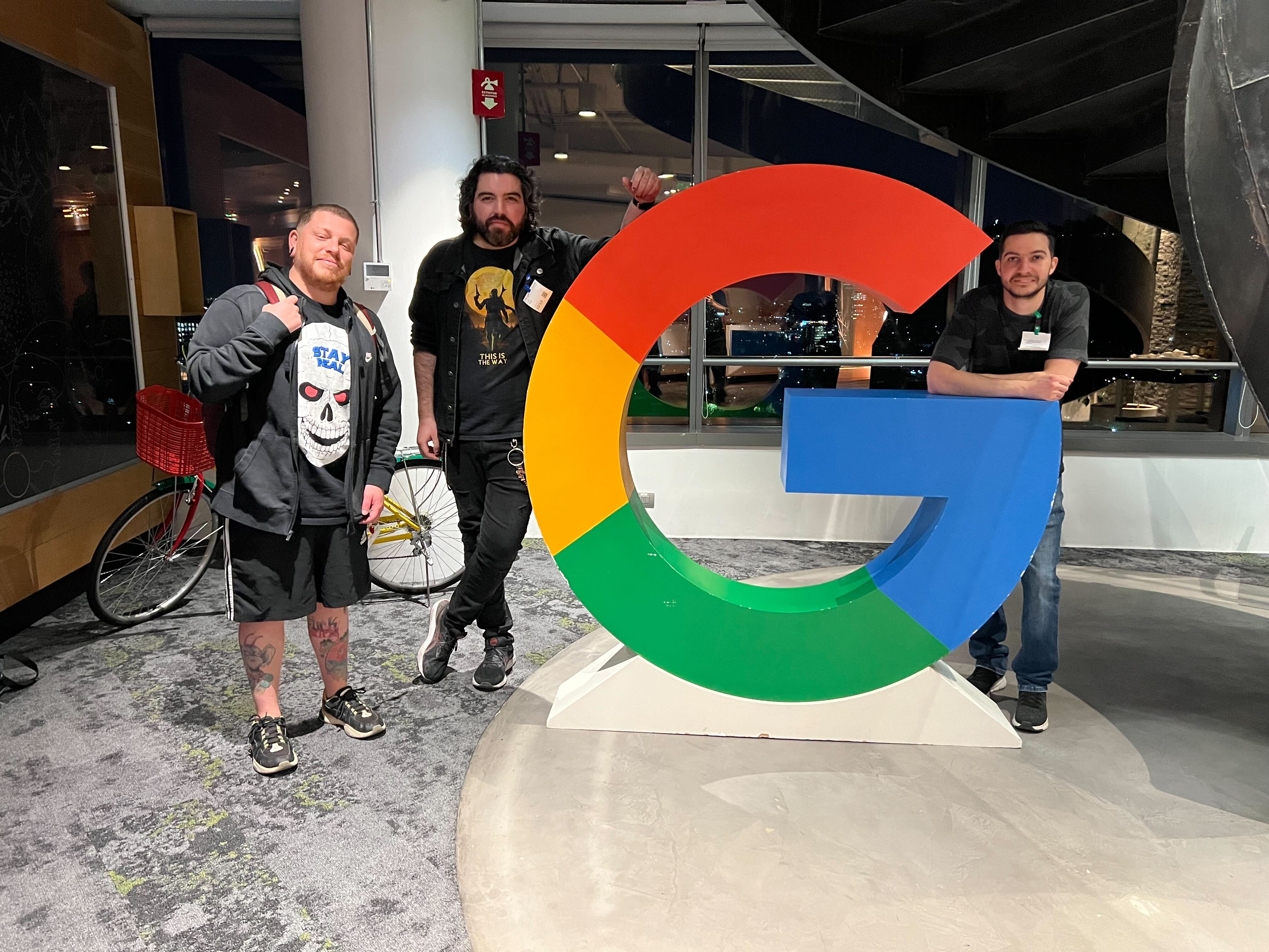 Amigos posando junto al logo gigante de Google